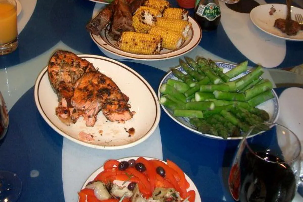 Barbecue salmon dinner with asparagus corn roasted peppers and black olives