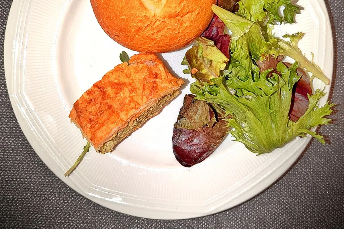 Chicken pesto tea sandwich plate with mixed greens fruit and a roll