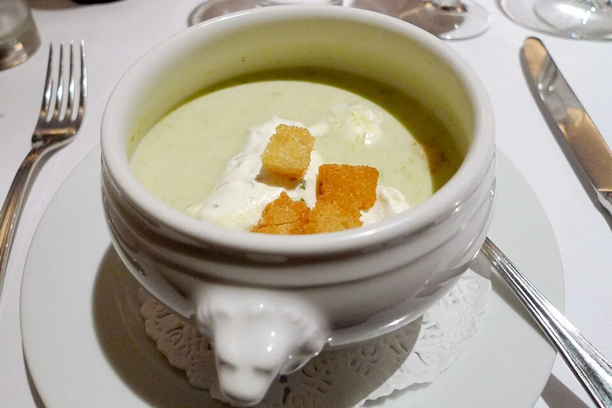 Smooth pale creamy leek soup topped with golden croutons