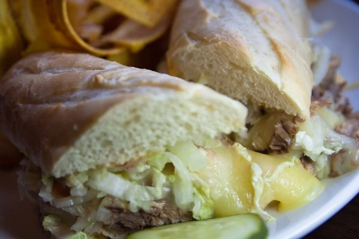 Roast pork sub sandwiches with melted Swiss shredded cabbage and pickle