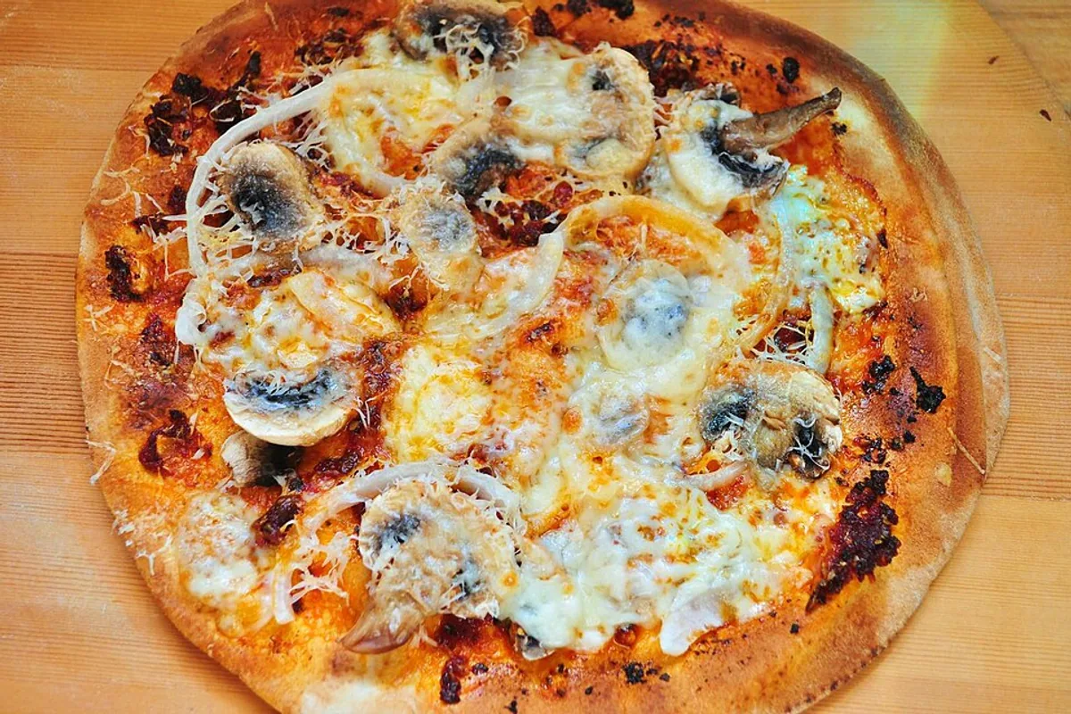 Pita bread pizza with tomato sauce mushrooms olives and mozzarella
