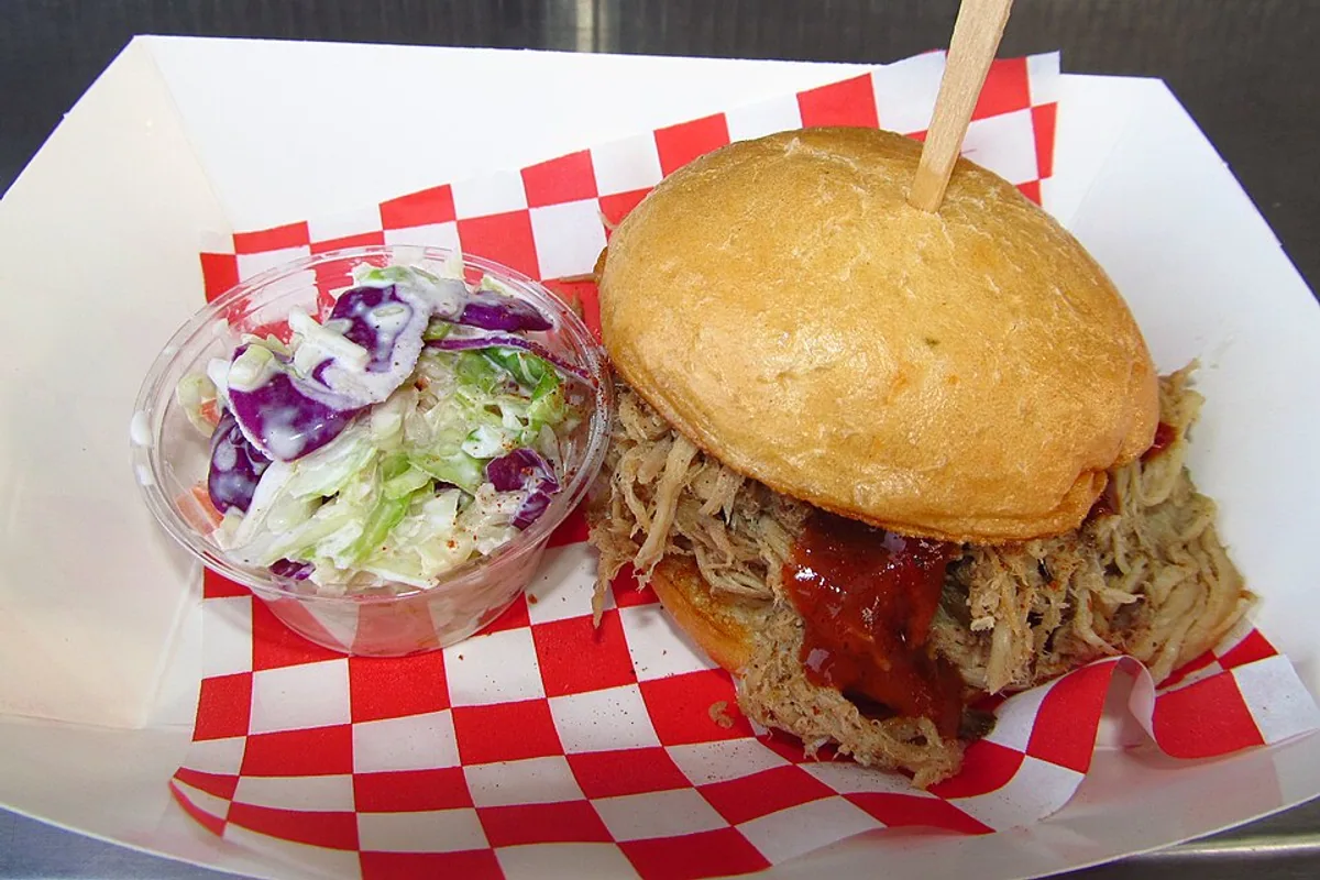 BBQ pulled pork slider on a soft bun with purple cabbage coleslaw