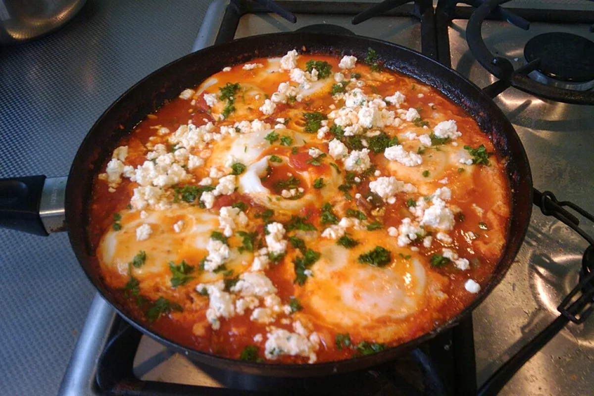 Shakshuka eggs in chile paprika tomato sauce with feta and parsley