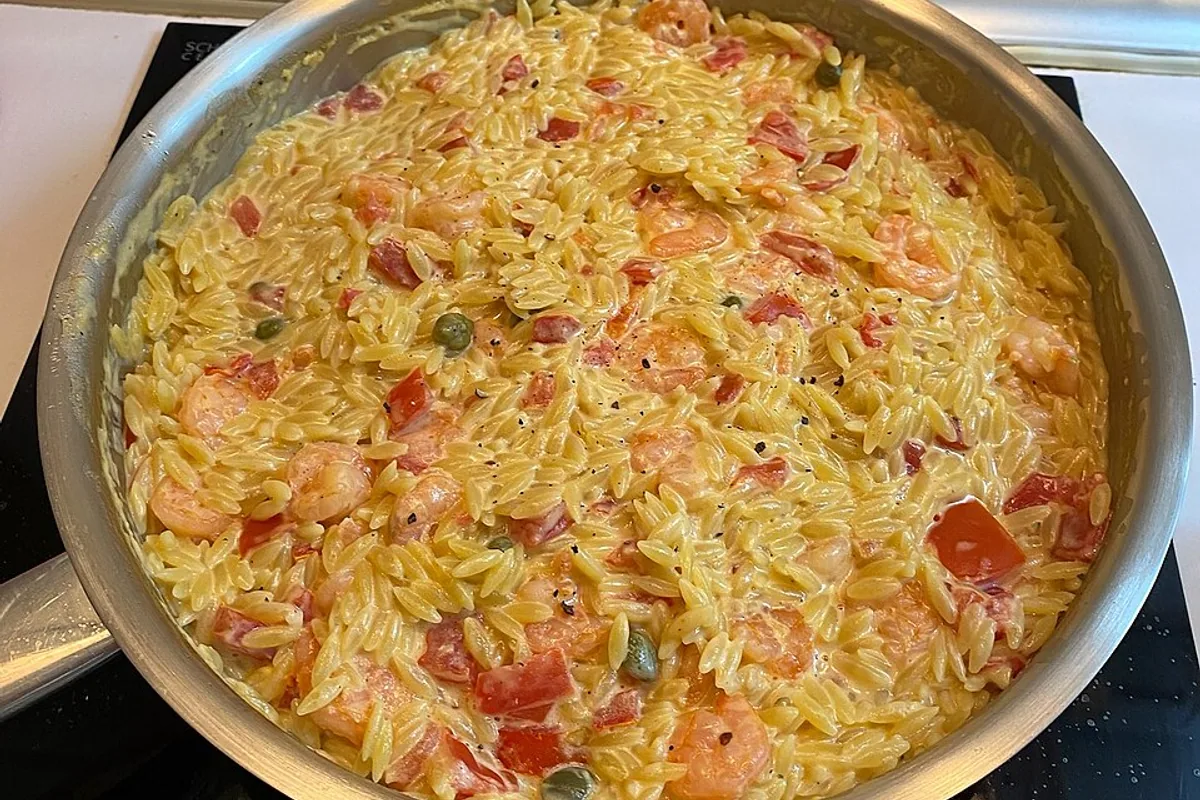 Creamy shrimp orzo with diced tomatoes and green peas