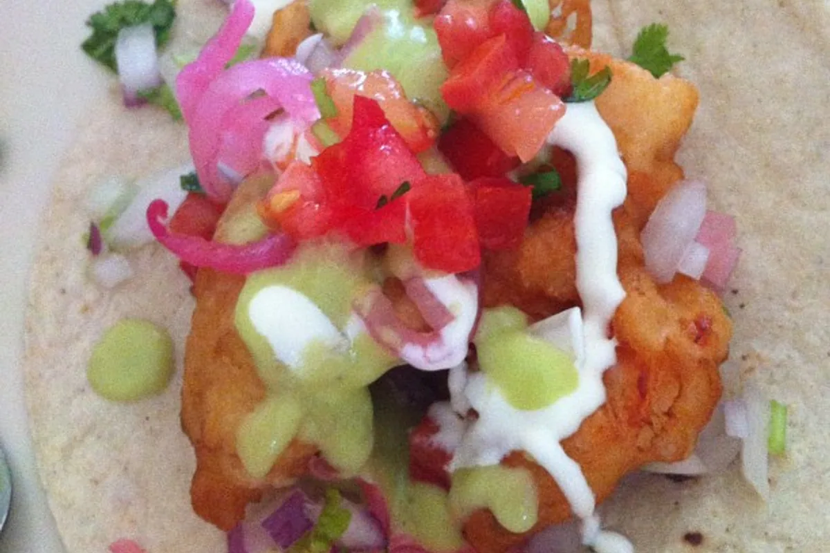 Shrimp taco with avocado salsa tomato pickled onion crema and lime